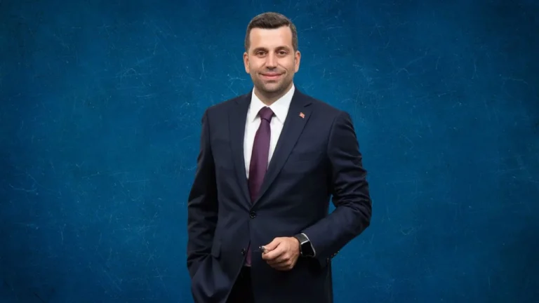 Takım elbiseli bir erkeğin mavi arka plan önündeki portresi